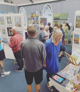 Visitors viewing original artwork at the hART 2023 exhibition in Hythe, Kent.
