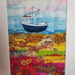 Colourful textile seascape by Carol Dixon featuring a fishing boat and layered stitched landscape