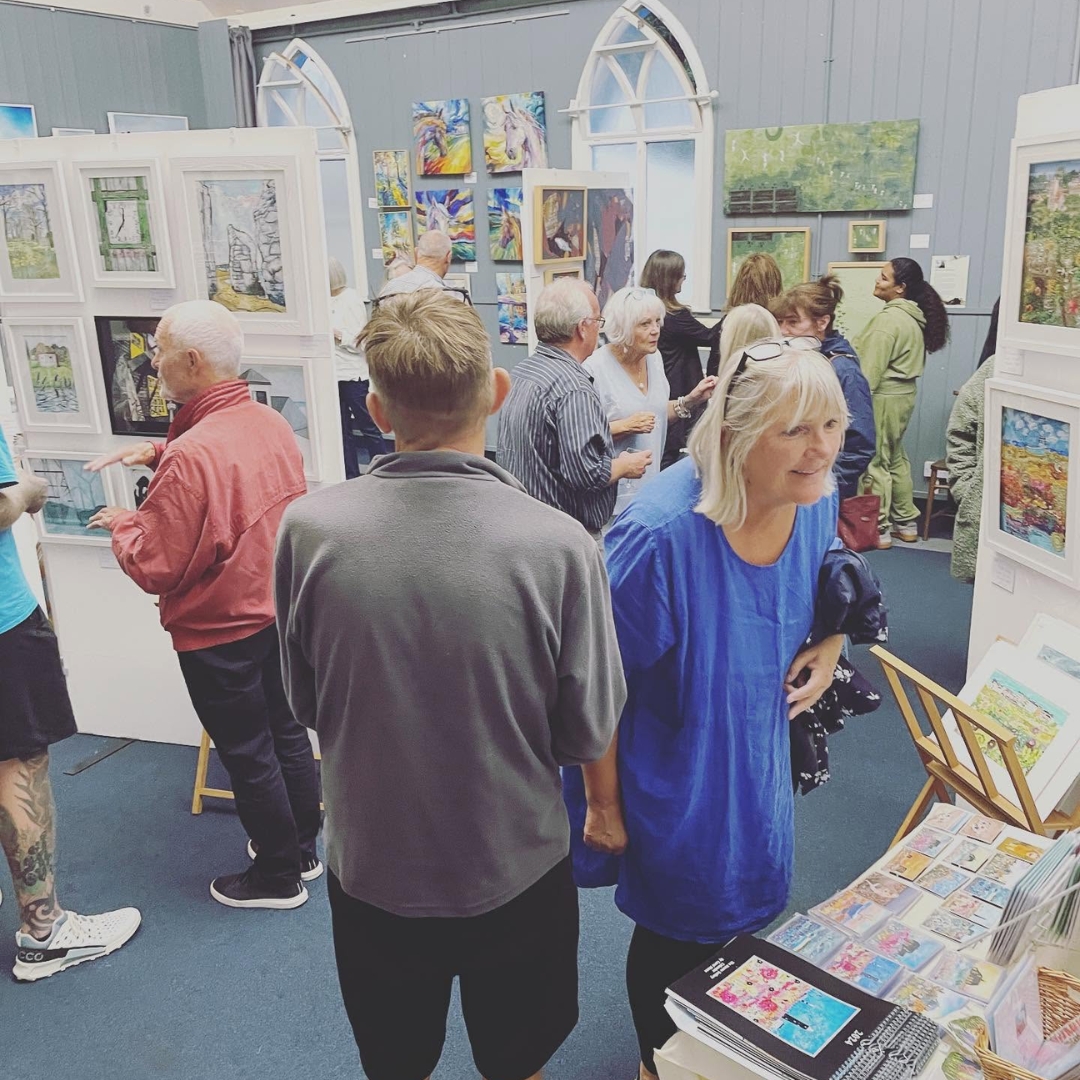 Visitors viewing original artwork by HART artists at a local art exhibition in Hythe, Kent.