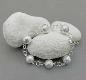 Silver bracelet by Julian Warrender featuring six intricately textured spherical beads linked with handcrafted silver rings.