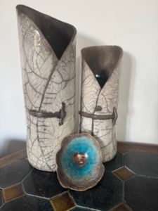 Sculptural Raku ceramics by Penny Graham featuring two tall crackle-glazed vessels with dark rims and a smaller turquoise circular form.