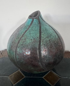 Raku ceramic vessel by Penny Graham with a rounded sculptural form, turquoise glaze and dark organic lines.