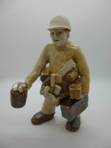 Handcrafted figurative sculpture of a tradesman carrying tools by artist Roger Sturley.